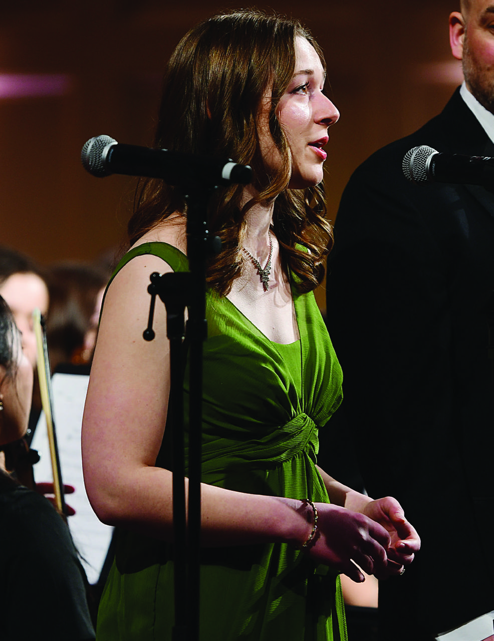 Right, senior Nora Russell sings a solo as the orchestra plays “Make Our Garden Grow.”
