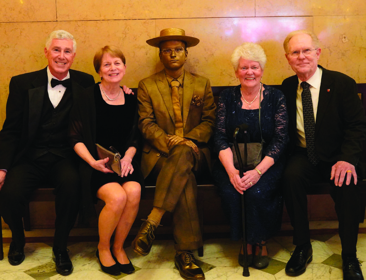 Below, alumni take a photo with senior Andrew Hoover dressed as the iconic statue of Pew.